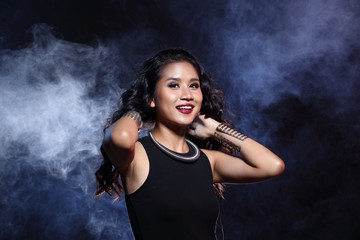 low key portrait of tan skin asian slim healthy woman in black background