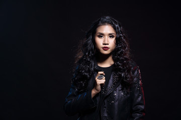 low key portrait of tan skin asian slim healthy woman in black background