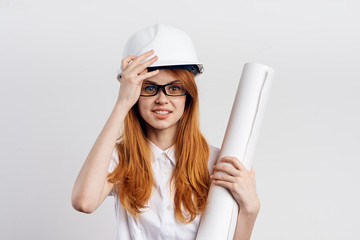 Beautiful young woman engineer on white isolated background holds blueprints
