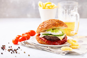 Cheeseburger on a plate and beer. Break. Snack. Selective focus. Copy space