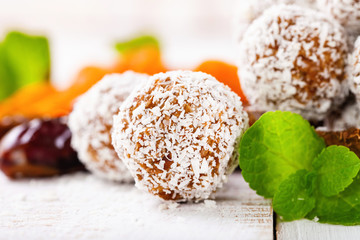 Homemade dietary candies from dates and an apricot in coconut topping. Selective focus. Copy space