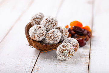 Homemade dietary candies from dates and an apricot in coconut topping. Selective focus. Copy space