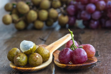 fresh logans and grapes on wood spoon