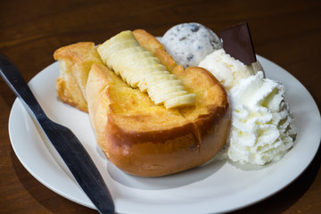 Honey toast bread serve with banana, ice cream and whipped cream