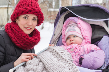 Beautiful mom and nice baby outdor in a winter