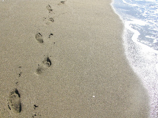 Foot print on sand at the beach background