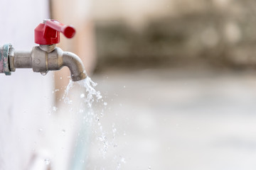 Closeup Tap with dripping water-drop. Saving water.