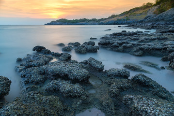 Stone in sea and wave on sunset time with long exposure at Ko Sichang District Chonburi, Thailand.
