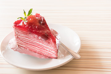 Strawberry crape cake in white plate with closeup view on wooden and ready to served in the morning.