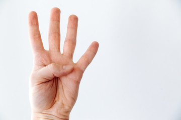 The hand shows four fingers on a white background.
