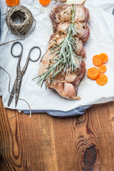 Fototapeta na wymiar Raw roast pork on rustic wooden kitchen table background with cooking strings and scissors, top view