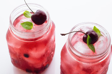 Two glass mugs with red drink and ice close-up. © ytochka89