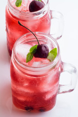 Glass mugs with a red drink, berries and ice. © ytochka89