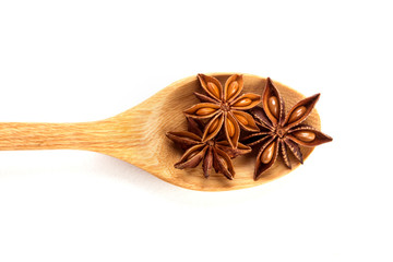 Close up the brown star anise spice in wooden spoon isolated on white background