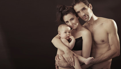 Happy family posing on black studio background