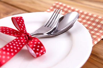 close up dinner setting fork and spoon on plate on wooden background