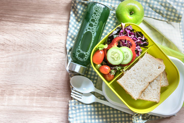 Fototapeta na wymiar The Healthy Lunch box with grain bread and green vegetable and fruit juice bottle on wooden background ,Healthy eating clean food habits for diet concept , top view and overhead shot