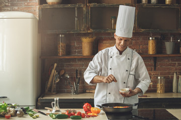  Mature man professional chef cooking meal indoors