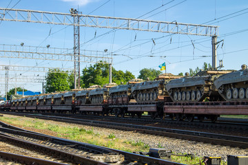 Cargo train carrying military tanks on railway flat wagons
