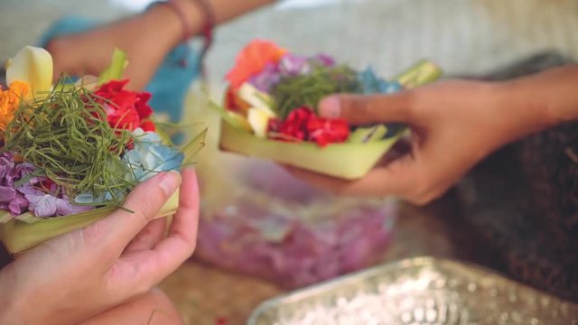 Two girls making balinese offerings Canang sari, slide