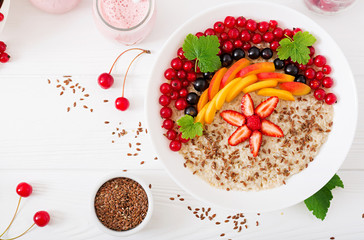 Tasty and healthy oatmeal porridge with berry, flax seeds and smoothies. Healthy breakfast. Fitness food. Proper nutrition. Top view. Flat lay