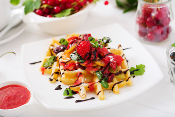 Variety of Belgian wafers with berries, chocolate and syrup. 