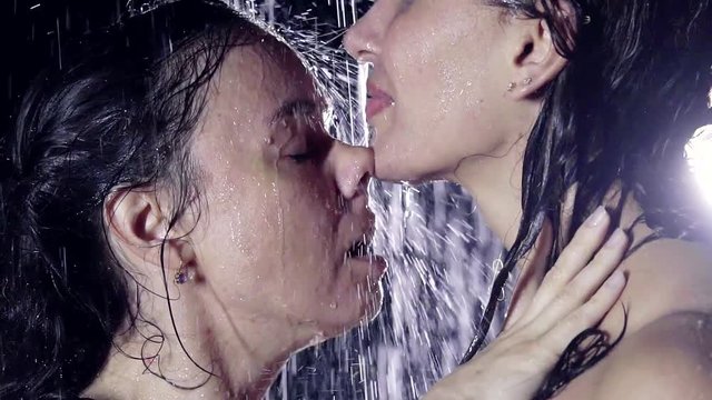 close-up portrait of girls lesbians in the profile. individuals with dripping water from the heavy rain. caress the chic and noses in a state of orgasm.