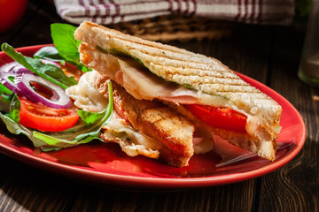 Toasted panini with ham, cheese and tomato sandwich
