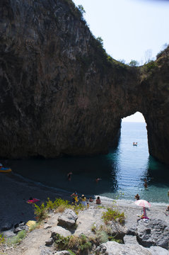 Calabria, Italia: la spiaggia dell'Arco Magno, una piccola baia nascosta con un arco naturale scavato dalle onde durante i secoli, vicino al paese di San Nicola Arcella