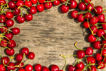 Frame of red cherry on wooden background