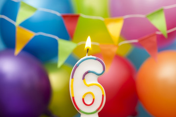 Happy Birthday number 6 celebration candle with colorful balloons and bunting
