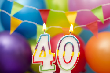 Happy Birthday number 40 celebration candle with colorful balloons and bunting