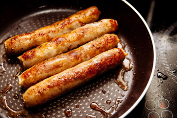 Sausages fried in a frying pan.