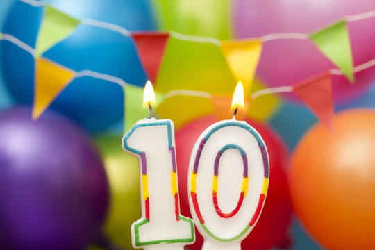 Happy Birthday number 10 celebration candle with colorful balloons and bunting