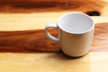 White cup on wood floor
