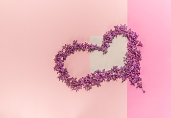 Heart of flowers of lilac. Background for a site design or landing page about food, health, flowers and spring. Layout on a pink background. A place for your inscriptions. The geometry of paper.