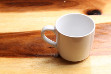 White cup on wood floor