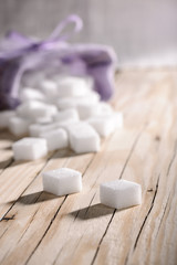 Fototapeta na wymiar White sugar cubes on wooden table