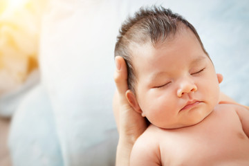 love and relationship in family. Mother holding head of her beautiful newborn daughter in hands....