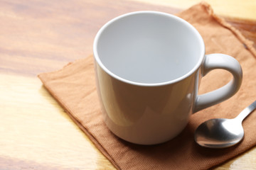 Fototapeta na wymiar white cup and spoon on wood floor