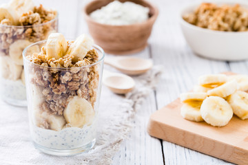 Chia pudding parfait, layered yogurt with banana, granola. Healthy breakfast