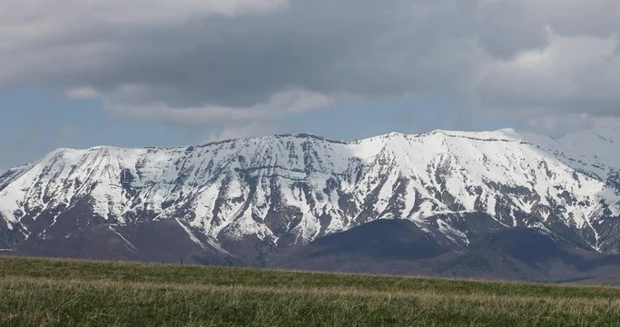Mount Nebo Utah spring snow mountain clouds fast motion. Wasatch Mountain range fast moving clouds on horizon of pine forest. Beautiful nature landscape. Uinta National Forest and wilderness area.