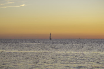 Obrazy na Szkle  Żaglowiec w romantycznym zachodzie słońca nad morzem