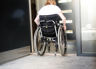 Person in a wheelchair moving over a low doorstep