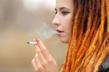 Obraz premium Young beautiful woman smoking weed, closeup