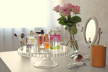 Stand with bottles of perfume on table