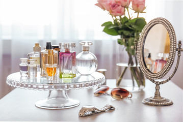 Stand with bottles of perfume on table