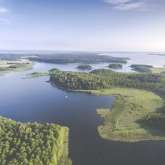 Aerial view of green islands and clouds at summer sunny morning. Masurian Lake District  in Poland.