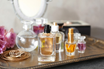 Obraz na płótnie Canvas Metal tray with bottles of perfume on table