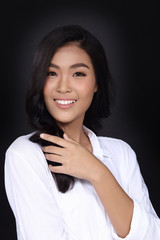 Smile with Teeth, Korea Girl black hair in white t shirt, half body portrait in studio lighting black background, hand on arm face, eyes look at camera